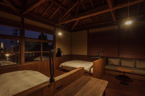 a room with a bed and a couch and a bedroom at awai 戸隠 in Nagano