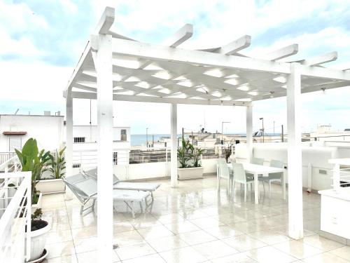 a white pergola on the roof of a building at Villa Azzurra in Marina di Mancaversa