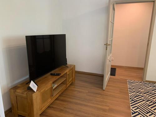 a living room with a flat screen tv on a wooden entertainment center at Valdemāra apartamenti in Valmiera