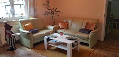a living room with two couches and a table at Ferienwohnung MAI in Glauchau