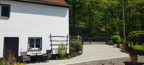 a white building with a table and chairs outside at Ferienwohnung MAI in Glauchau