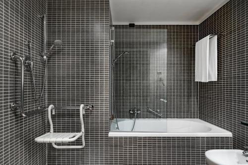 a bathroom with a bath tub and a sink at AC Hotel Firenze by Marriott in Florence