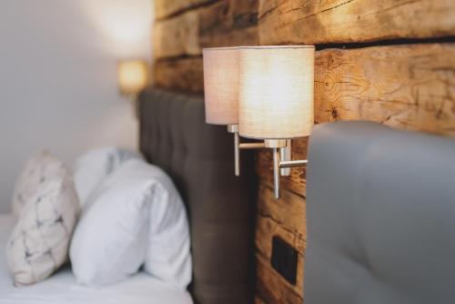 a lamp on a wall next to a bed at Chalet Badia by we rent, SUMMERCARD INCLUDED in Zell am See