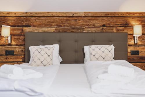 a bedroom with a bed with white sheets and pillows at Chalet Badia by we rent, SUMMERCARD INCLUDED in Zell am See