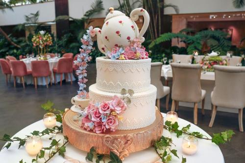 a wedding cake with a teapot on top of it at The Westin Camino Real, Guatemala in Guatemala