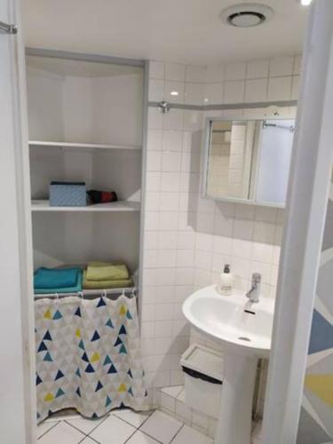 une salle de bain blanche avec un lavabo et un miroir dans l'établissement Charmant studio hypercentre, à Rouen