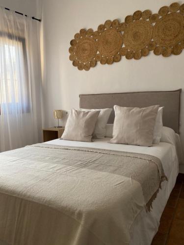 ボロニアにあるHabitaciones Carmencitaのベッドルーム1室(大型ベッド1台、白いシーツ、枕付)