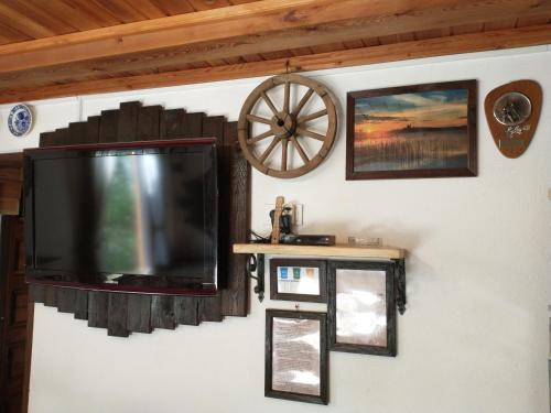 telewizor z płaskim ekranem wiszący na ścianie z obrazami w obiekcie Wigierska Chatka w Gawrych Rudzie