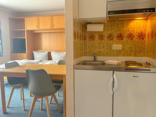 eine Küche mit einem Tisch, einem Waschbecken und einem Bett in der Unterkunft Haus Tida in Norderney