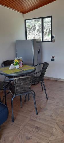 a table and chairs in a room with two windows at Cabañas Villas Del Lago in Cuítiva