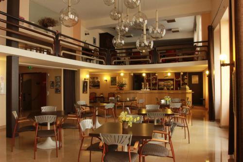 a restaurant with tables and chairs in a room at Hôtel Saint Sébastien in Lourdes