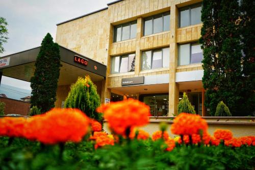 a building with orange flowers in front of it at Hotel Lago Peshtera in Peshtera