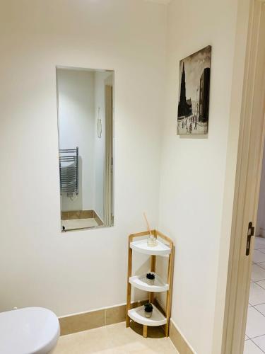 a white bathroom with a mirror and a stool at Victoria Rooms in Manchester