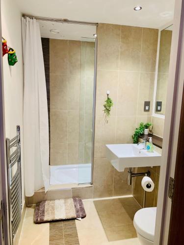 a bathroom with a shower and a sink and a toilet at Victoria Rooms in Manchester