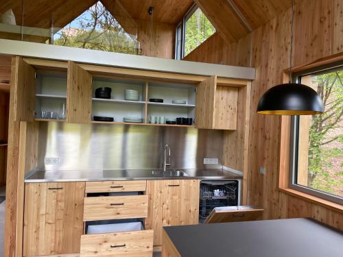 a kitchen with wooden cabinets and a black lamp at Baumwipfelhaus in Annweiler am Trifels