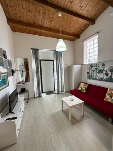 uma sala de estar com um sofá vermelho e uma mesa em Cami s holidays home mare em Catânia