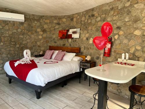 1 dormitorio con cama y mesa con globos en Cabañas Caballieri, en Pisco Elqui