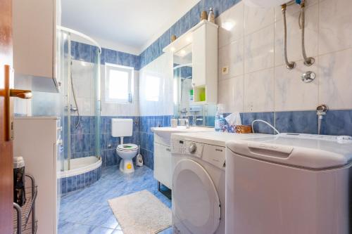a bathroom with a washing machine and a sink at Lanterna Puntamika apt. near beach in Zadar