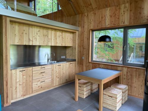 a kitchen with wooden cabinets and a table at Baumwipfelhaus in Annweiler am Trifels