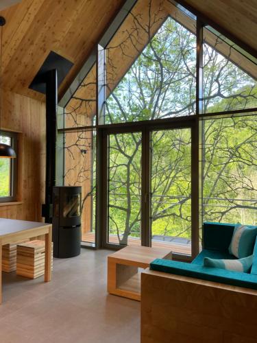 a living room with large windows and a blue couch at Baumwipfelhaus in Annweiler am Trifels