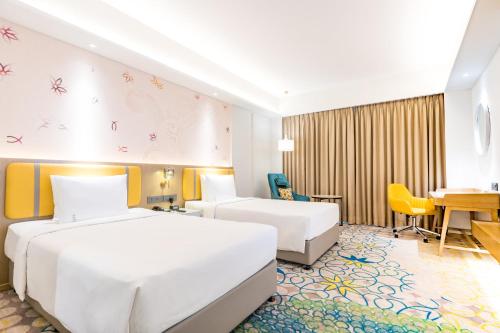 a hotel room with two beds and a desk at Holiday Inn Lucknow Airport by IHG in Lucknow