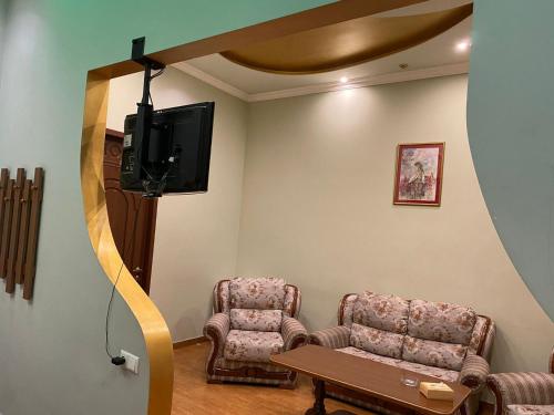una sala de espera con 2 sillas y TV de pantalla plana en Green House, en Pʼarakʼar