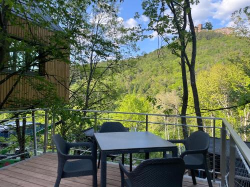 a table and chairs on a deck with a view at Baumwipfelhaus in Annweiler am Trifels