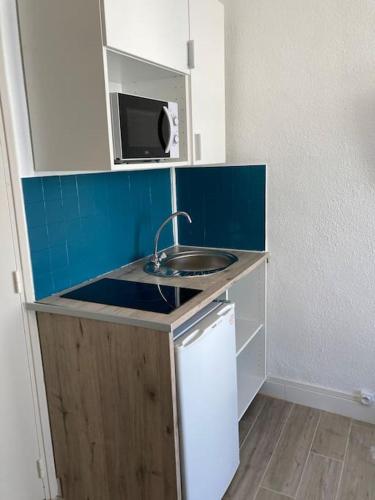 une petite cuisine avec un évier et un micro-ondes dans l'établissement 013 - Cosy Studio, Place Comédie Gare St Roch, à Montpellier
