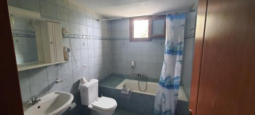 a bathroom with a toilet and a tub and a sink at Molivos Castle Apartments in Mythimna