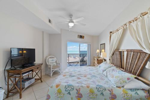 ein Schlafzimmer mit Bett und Flachbildfernseher in der Unterkunft Luxury Direct Beachfront Views - Crimson #201 in St Pete Beach