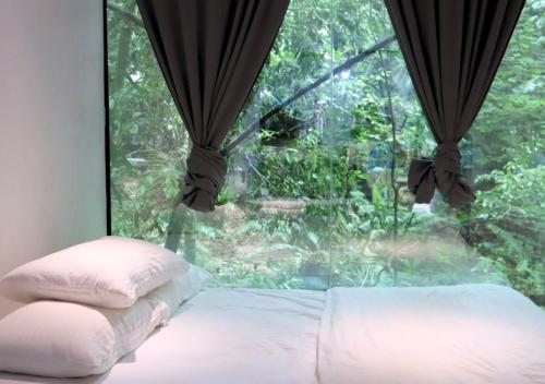 1 dormitorio con ventana, cama y almohada en Time Capsule Retreat, Sungai Lembing, en Sungai Lembing