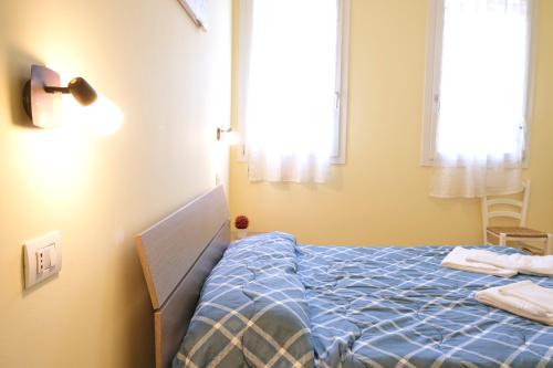 a bedroom with a bed with a blue comforter and a window at Agriturismo Da Rosy in Codevigo