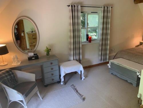 a bedroom with a desk and a bed and a mirror at Self catering cottage in Market Bosworth in Market Bosworth