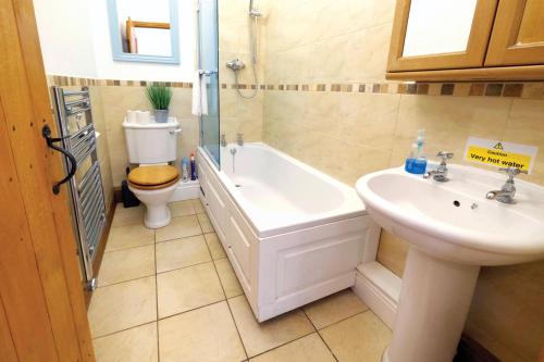 a bathroom with a sink and a tub and a toilet at Ocean View Cottage 2 - 2 Bed Cottage - Llanrhidian in Llanrhidian