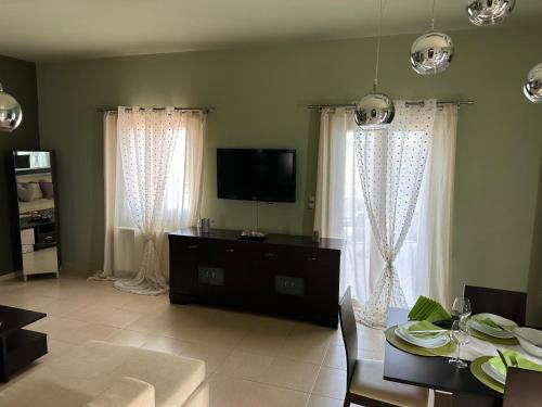 a living room with a table and a tv and curtains at Eva’s House in Vari