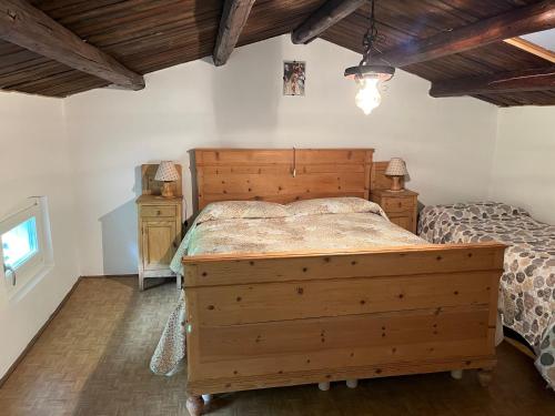 a bedroom with a wooden bed in a room with wooden ceilings at ALTRAVISTA TARZO in Revine Lago