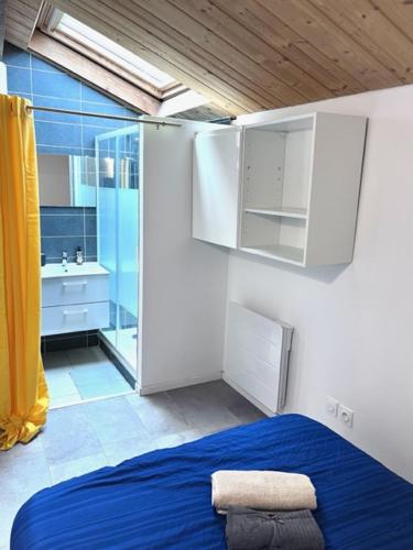 - une chambre avec un lit bleu et une salle de bains dans l'établissement Magnifique appartement avec terrasse Roof-Top, à Saint-Étienne