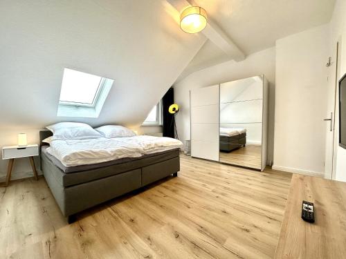 1 dormitorio con cama y espejo grande en Zentral gelegene DG-Wohnung mit 4 Schlafzimmern, en Eisenach