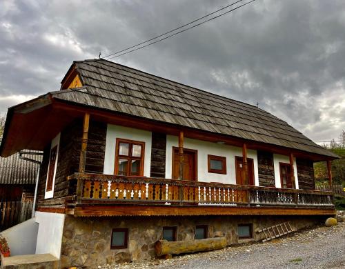 a house with a balcony on top of it at Biotour Camping & Restaurant in Ghimeş