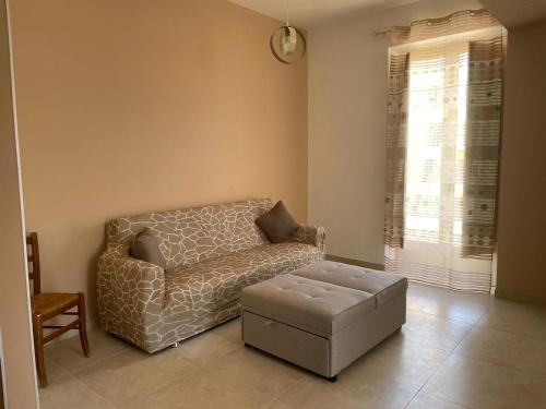 un soggiorno con divano e sgabello di da nonna melina a Licata