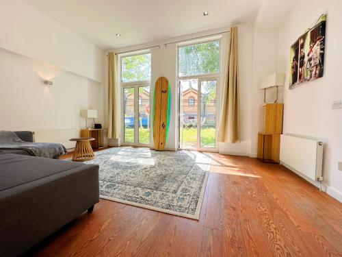 a living room with a bed and a surfboard at Portobello Dock - Canal Views with Garden in London