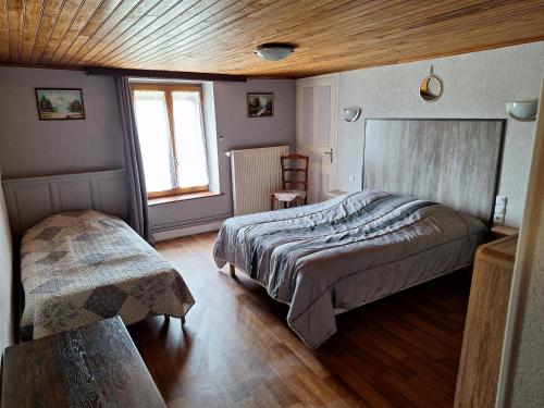1 dormitorio con cama y techo de madera en Maison De Vacances, en Blondefontaine
