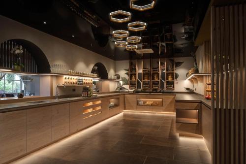 a large kitchen with a large counter with lights at Hotel Burggräflerhof in Merano