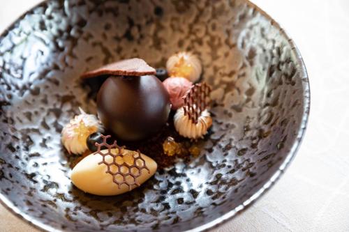 a metal bowl with chocolate and other food in it at Hotel Burggräflerhof in Merano