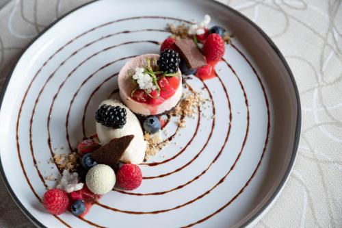 a dessert with fruit on a plate on a table at Hotel Burggräflerhof in Merano
