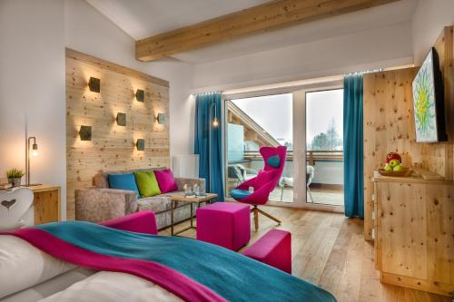 a bedroom with a bed and a living room at Impuls Hotel Tirol in Bad Hofgastein
