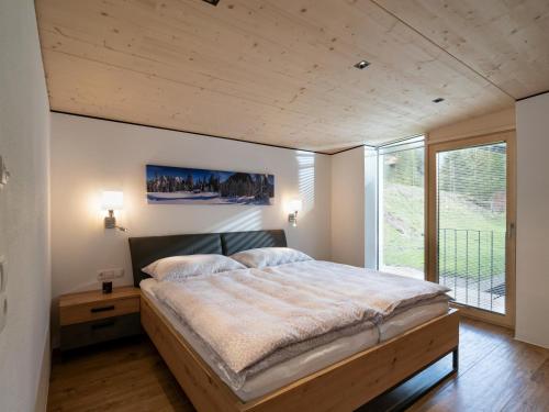 a bedroom with a large bed and a large window at Ferienwohnung Auszeit am See in Achensee