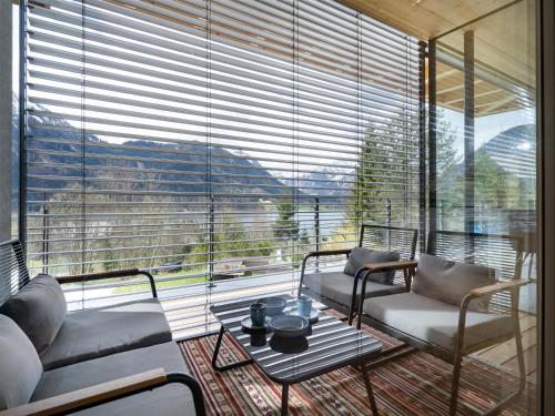 a living room with a large window with couches and a table at Ferienwohnung Auszeit am See in Achensee