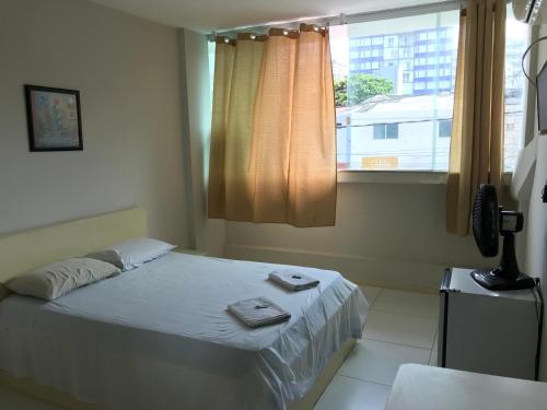 ein Schlafzimmer mit einem Bett mit zwei Handtüchern darauf in der Unterkunft Hotel Minas Salvador in Salvador