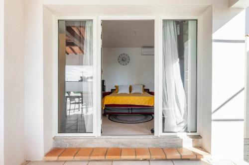 a bedroom with a bed through a sliding glass door at Studio neuf avec acces piscine in Valergues